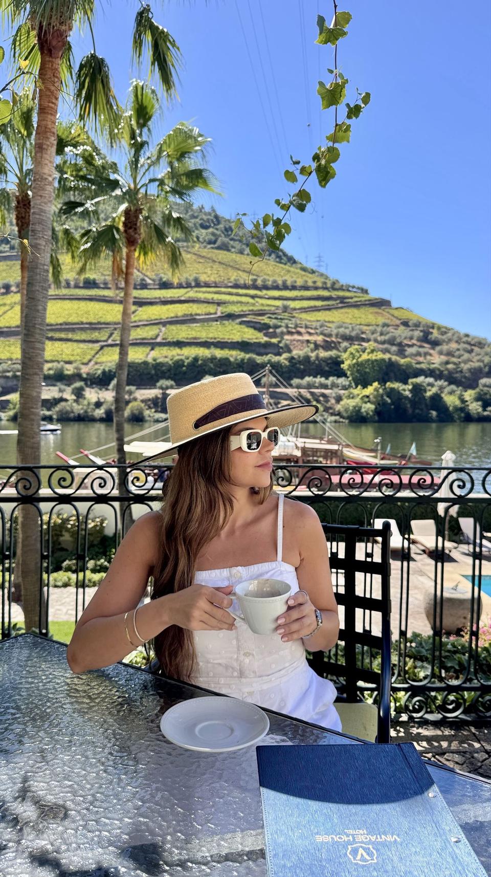 Juliana Brandão with a coffee on a riverside terrace in the Douro Valley, Portugal