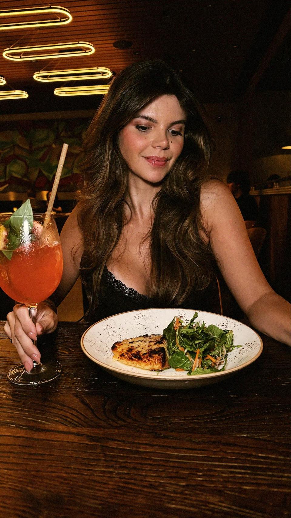 Juliana Brandão at dinner with a spritz in a Miami restaurant