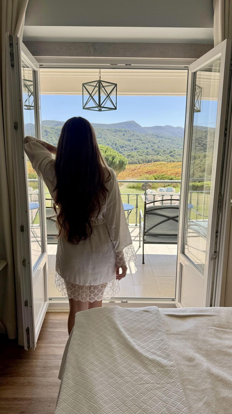 Open balcony doors over vineyards and the Arrábida hills